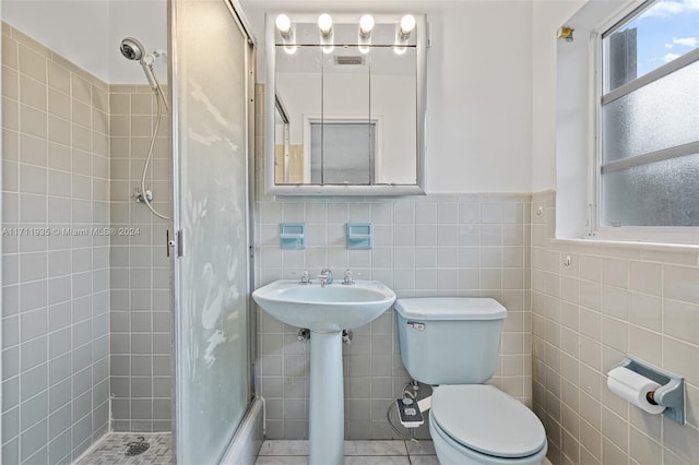 bathroom featuring sink, tile patterned flooring, tile walls, and toilet