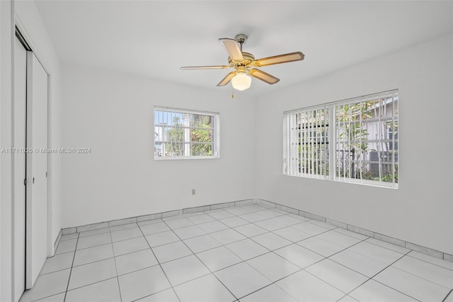 empty room with light tile patterned floors and ceiling fan