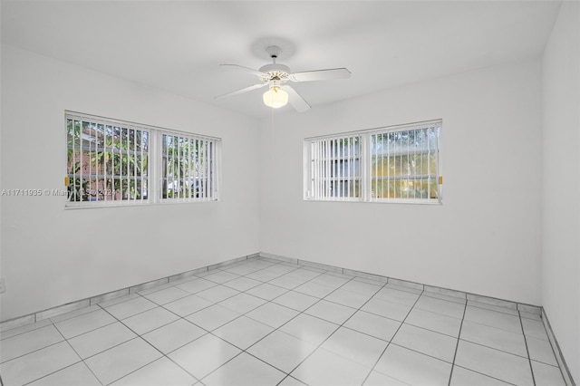 tiled spare room with ceiling fan