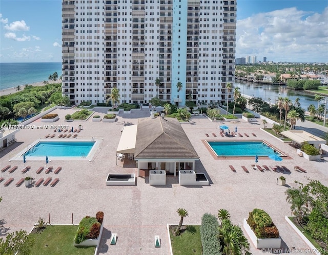 view of swimming pool with a patio area and a water view