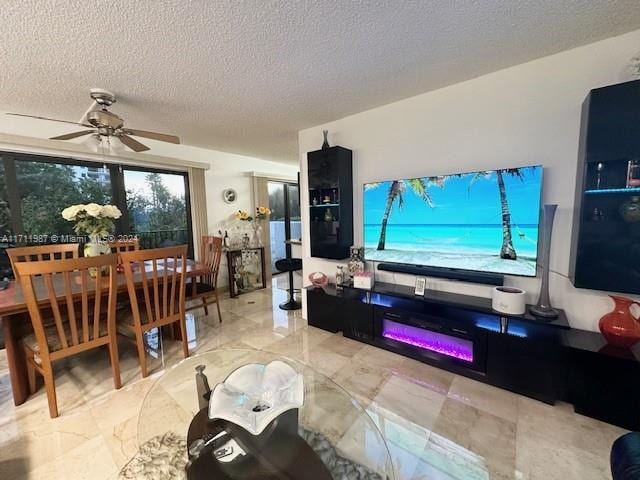 living room with ceiling fan and a textured ceiling