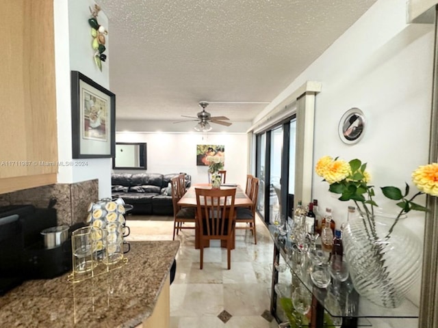 dining area with a textured ceiling and ceiling fan