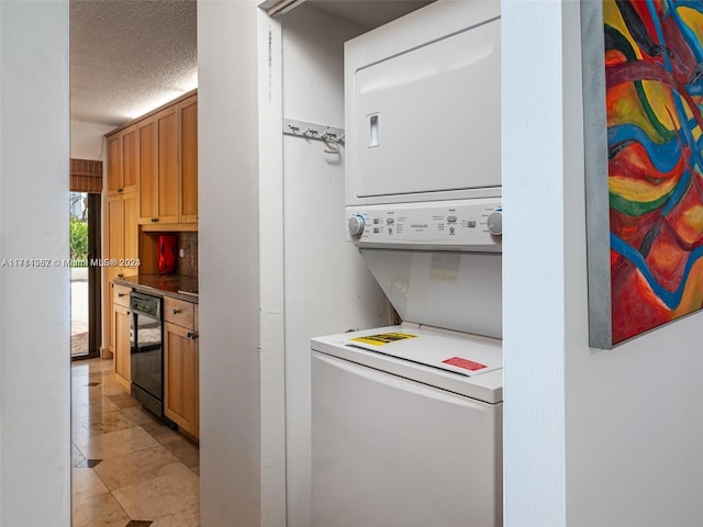 laundry room with stacked washer / dryer and a textured ceiling