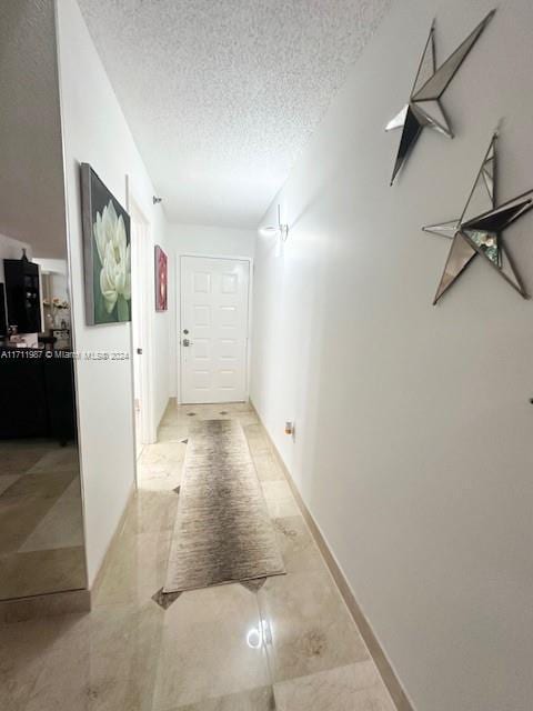 hall featuring a textured ceiling