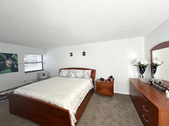 bedroom featuring carpet and a textured ceiling