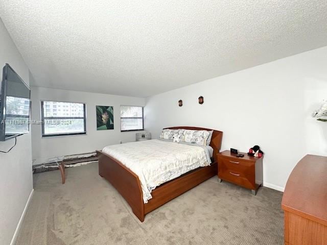 bedroom with light carpet and a textured ceiling