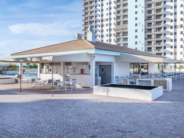 surrounding community featuring a swimming pool, a bar, and a patio