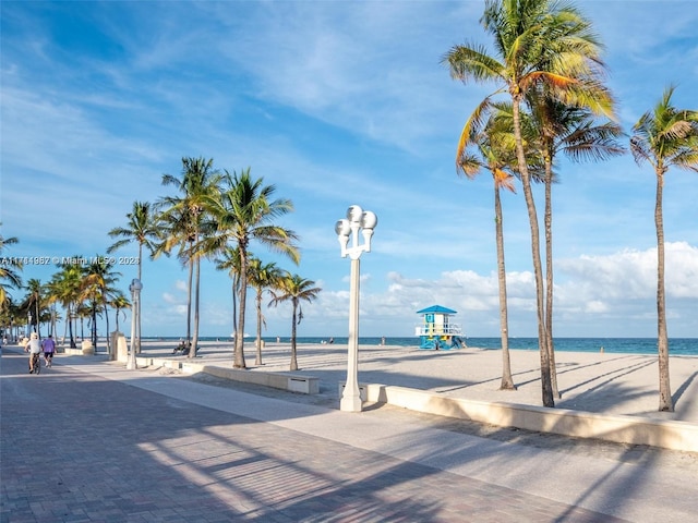 view of property's community featuring a water view and a beach view