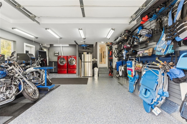 garage featuring stainless steel refrigerator and washing machine and clothes dryer