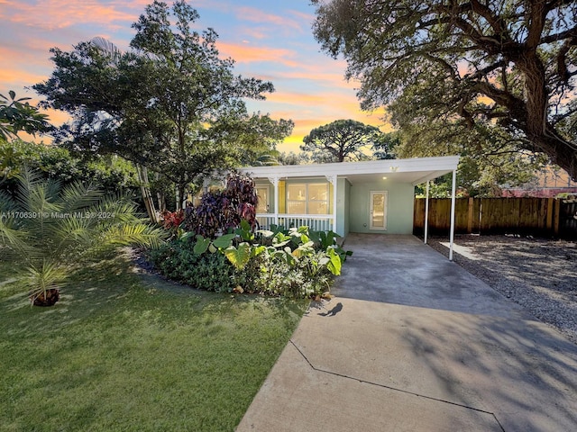 view of front of house featuring a yard, covered porch, and a carport