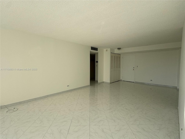 spare room with a textured ceiling