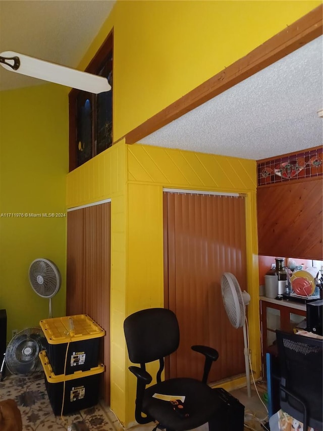 office space with wood walls and a textured ceiling