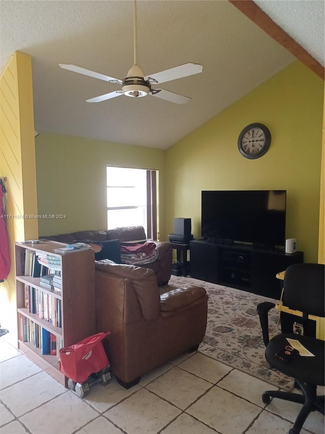 living room with lofted ceiling with beams, ceiling fan, light tile patterned floors, and a textured ceiling