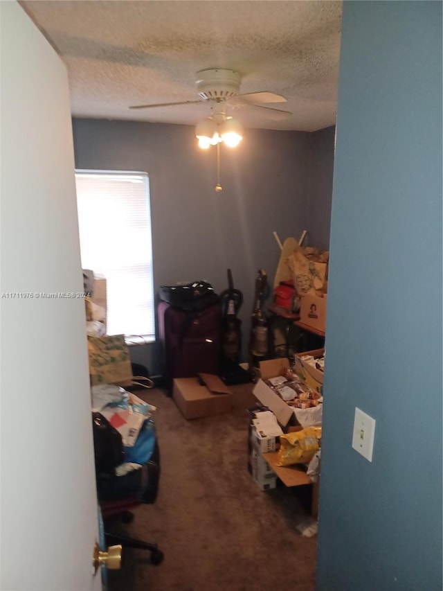 interior space with ceiling fan, carpet floors, and a textured ceiling