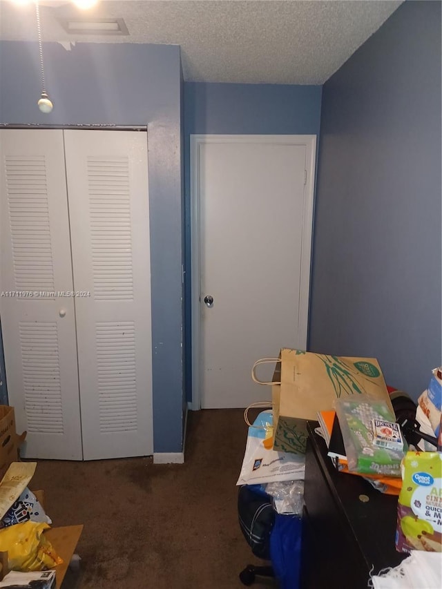 carpeted bedroom with a textured ceiling and a closet