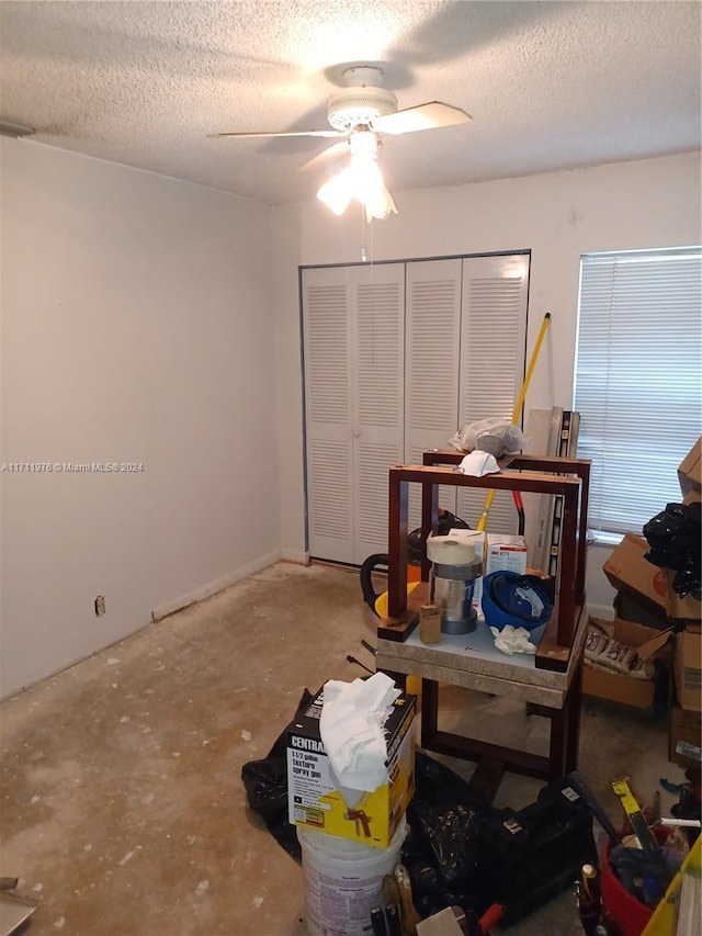 miscellaneous room with concrete flooring, a textured ceiling, and ceiling fan