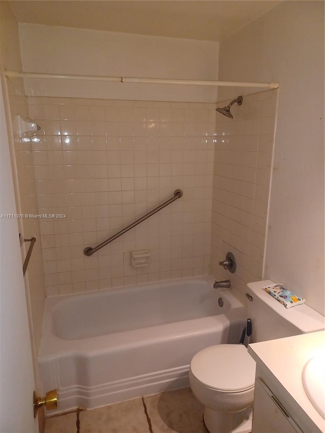 full bathroom with tiled shower / bath, tile patterned floors, vanity, and toilet