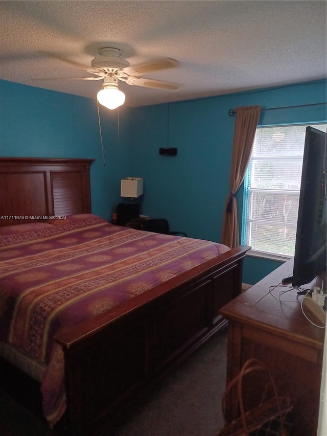 carpeted bedroom with ceiling fan and a textured ceiling