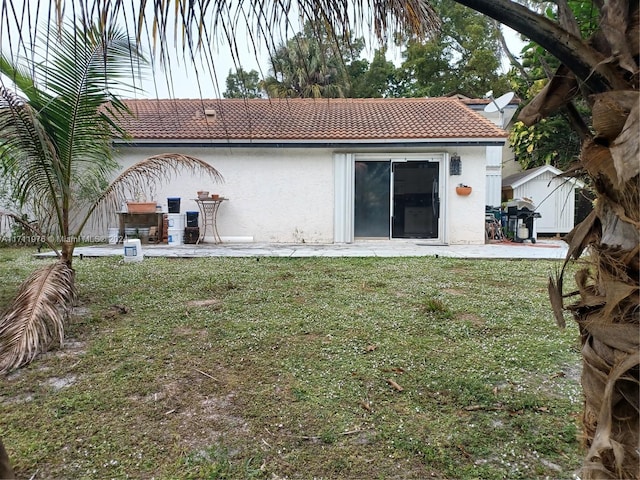 rear view of property featuring a lawn