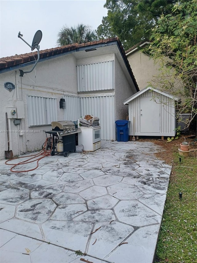 view of patio with grilling area and a storage unit