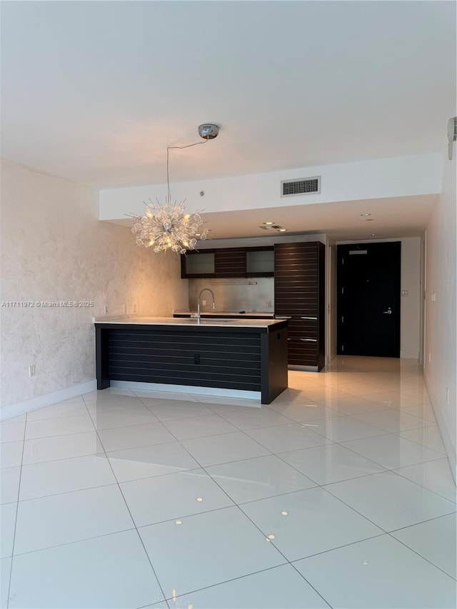 kitchen with decorative light fixtures, light tile patterned floors, light countertops, visible vents, and a chandelier