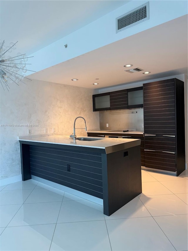 kitchen featuring light tile patterned floors, visible vents, light countertops, and a sink