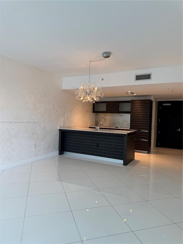 kitchen with light tile patterned floors, a chandelier, a sink, visible vents, and light countertops