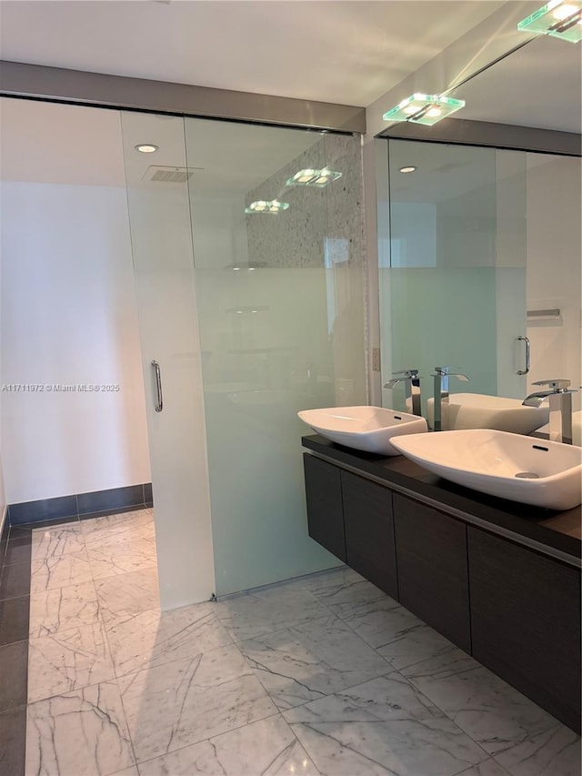 full bath with marble finish floor, visible vents, a sink, and double vanity