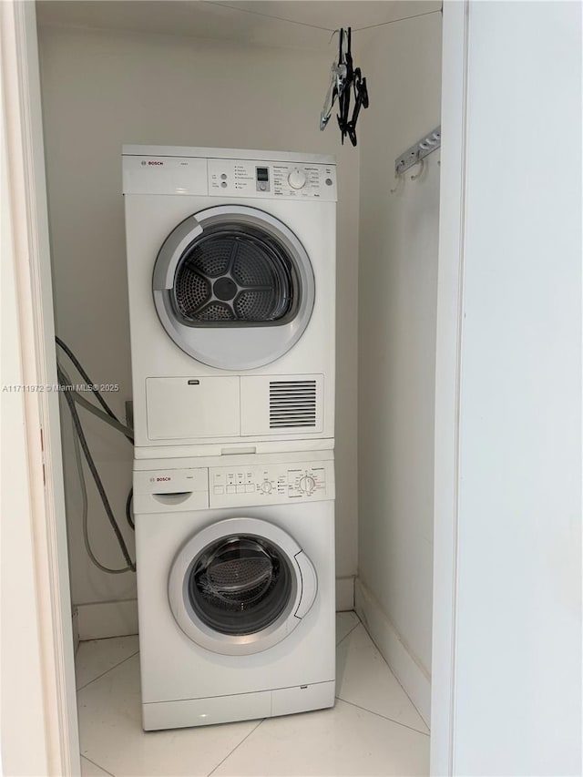 washroom featuring light tile patterned flooring and stacked washer / drying machine