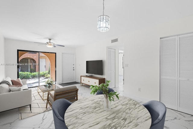 living room with ceiling fan with notable chandelier