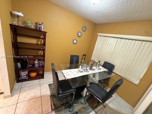 tiled dining area featuring a textured ceiling