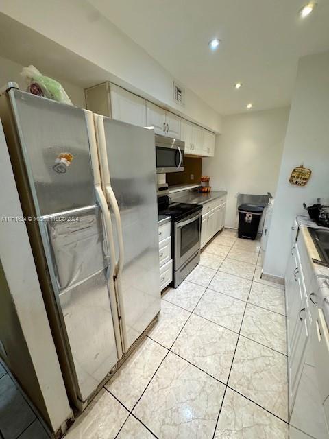 kitchen with white cabinets and appliances with stainless steel finishes