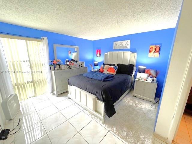 tiled bedroom featuring a textured ceiling