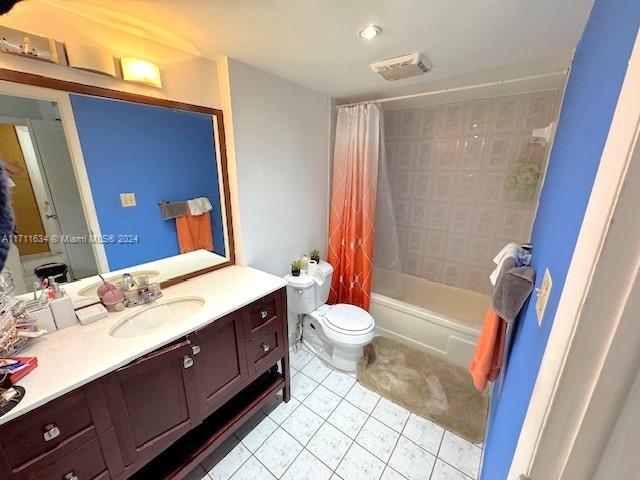 full bathroom featuring toilet, vanity, shower / tub combo with curtain, and tile patterned flooring