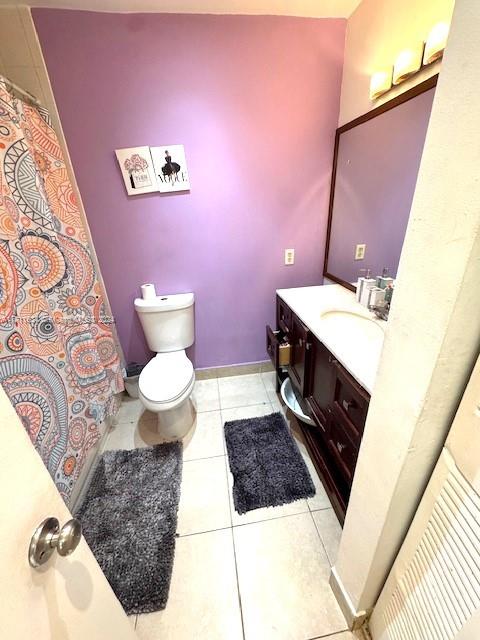 bathroom with tile patterned flooring, vanity, and toilet