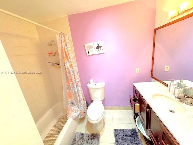 full bathroom featuring tile patterned flooring, vanity, shower / bath combination with curtain, and toilet