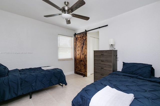 tiled bedroom with a barn door and ceiling fan