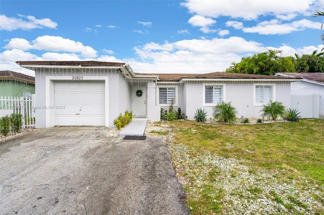 single story home featuring a front lawn and a garage