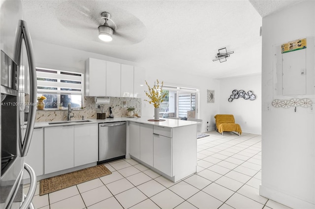 kitchen featuring white cabinets, stainless steel appliances, a wealth of natural light, and sink