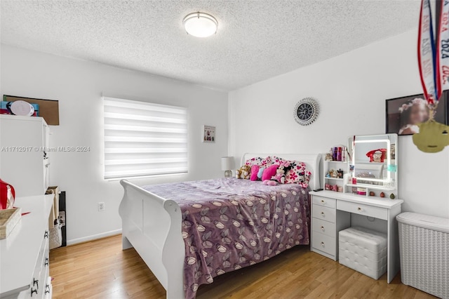 bedroom featuring a textured ceiling and light wood-type flooring