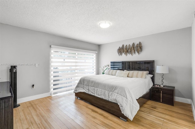 bedroom featuring a textured ceiling and light wood-type flooring