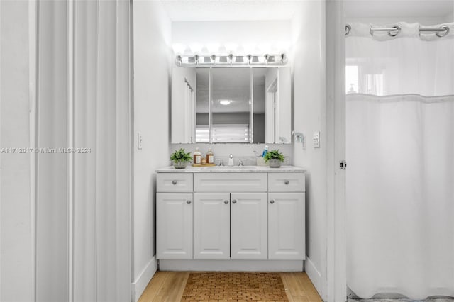 bathroom with hardwood / wood-style floors, vanity, and a shower with shower curtain