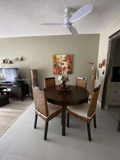 dining area featuring ceiling fan, a textured ceiling, and hardwood / wood-style flooring