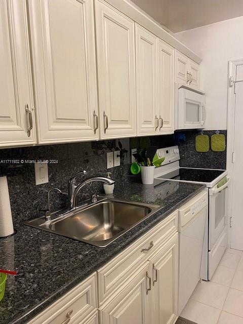 kitchen featuring tasteful backsplash, sink, and white appliances