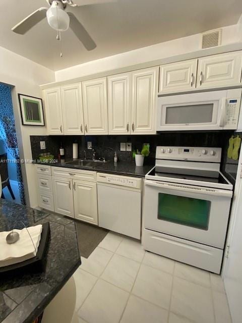 kitchen with tasteful backsplash, white appliances, sink, light tile patterned floors, and white cabinets