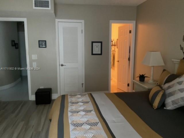 bedroom featuring hardwood / wood-style floors and ensuite bathroom