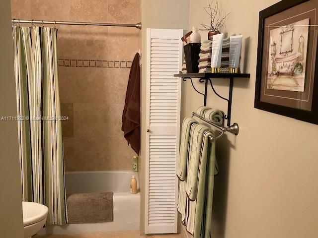 bathroom featuring shower / bath combo with shower curtain and toilet