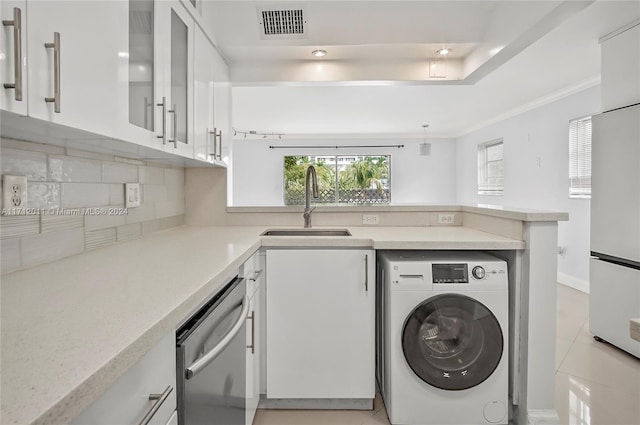 clothes washing area featuring washer / clothes dryer, sink, light tile patterned floors, and ornamental molding