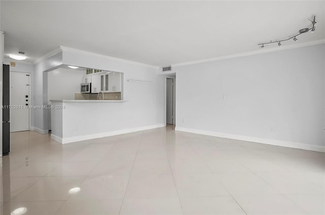 unfurnished living room featuring sink, crown molding, and light tile patterned flooring