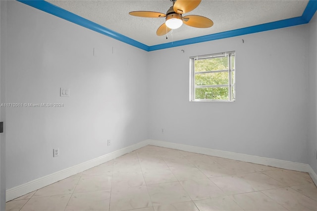 empty room featuring ceiling fan, a textured ceiling, and ornamental molding